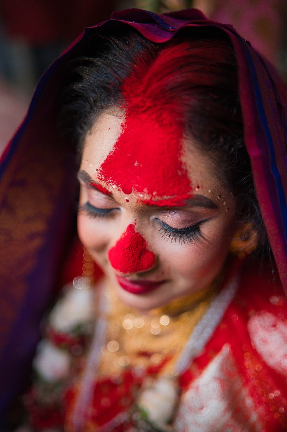 Reaching for the sindoor, Bengali wedding photography by Subho Parinay